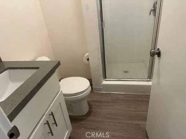 an empty room with wooden floor closet and windows