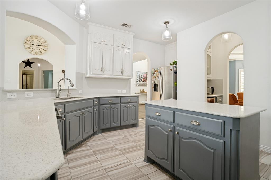 1461 Ramsbury Lane Prosper, TX 75078 - Photo 8 of 30 Kitchen featuring an island, light-toned countertops, contrasting grey and white cabinetry, recessed lighting, and tile flooring