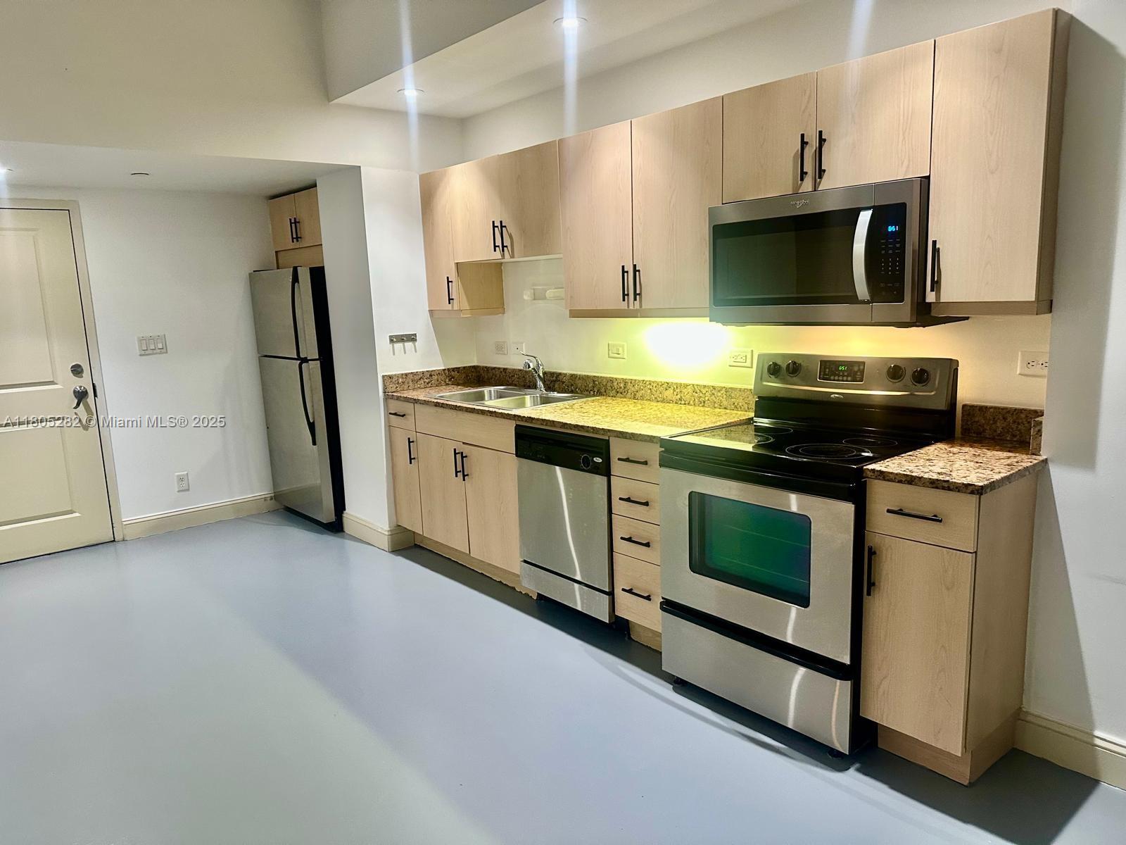 111 East Flagler Street, Unit 702 Miami, FL 33131 - Photo 4 of 11 a kitchen with a stove and a microwave