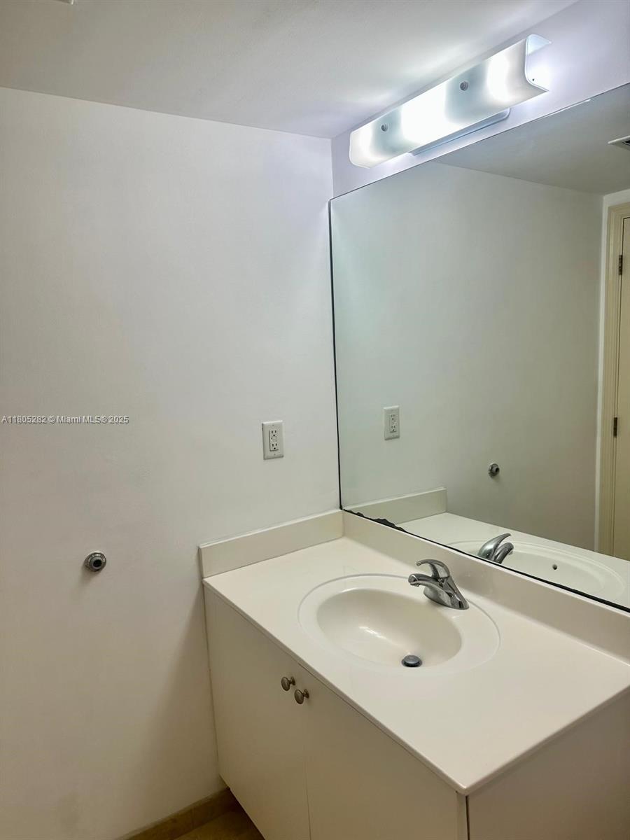 111 East Flagler Street, Unit 702 Miami, FL 33131 - Photo 9 of 11 a bathroom with a sink and a mirror
