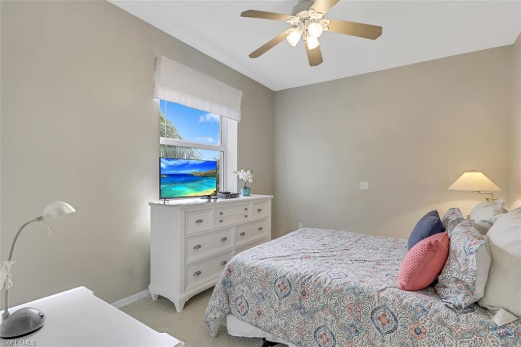 450 Launch Circle, Unit 404 Naples, FL 34108 - Photo 13 of 32 a bedroom with a bed and a chandelier