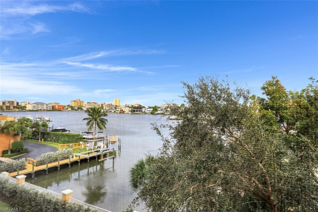 450 Launch Circle, Unit 404 Naples, FL 34108 - Photo 17 of 32 a view of a lake with houses in the back
