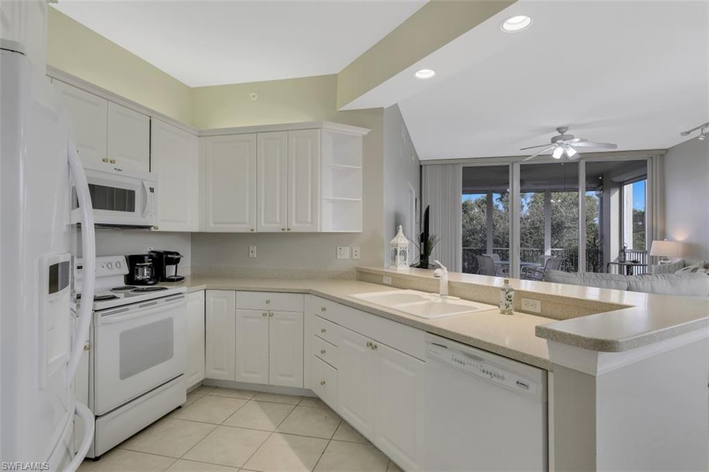 450 Launch Circle, Unit 404 Naples, FL 34108 - Photo 5 of 32 a kitchen with a sink stove and cabinets