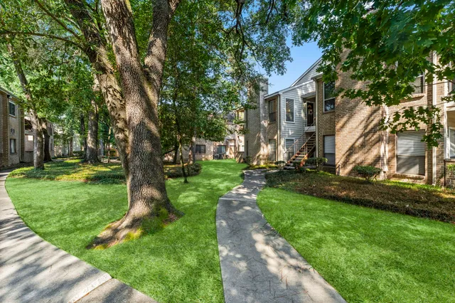 a front view of a house with a yard and tree