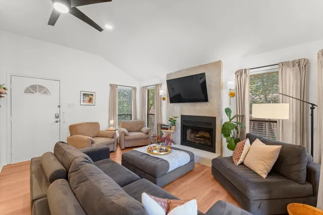 a living room with furniture a fireplace and a flat screen tv