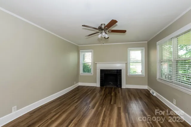 a view of empty room with wooden floor and fireplace