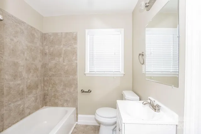 a bath room with a toilet a sink and a bath tub