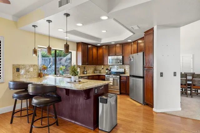 a kitchen with stainless steel appliances granite countertop a sink a stove and a refrigerator