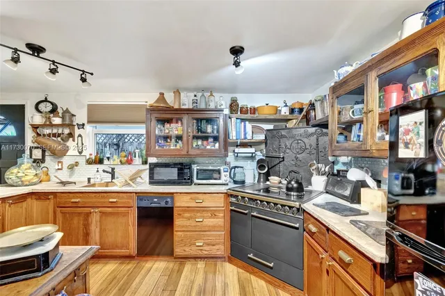 a kitchen with a stove and a wooden floor