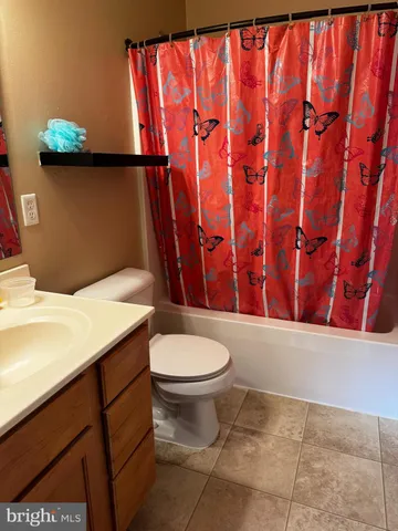 a bathroom with a toilet and shower curtain