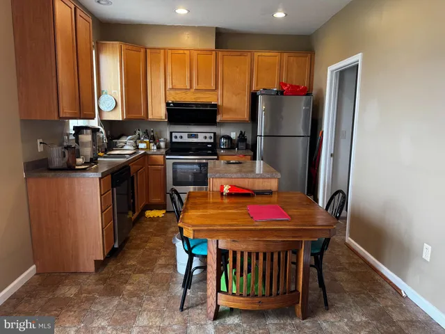a kitchen with stainless steel appliances granite countertop a stove refrigerator sink and cabinets