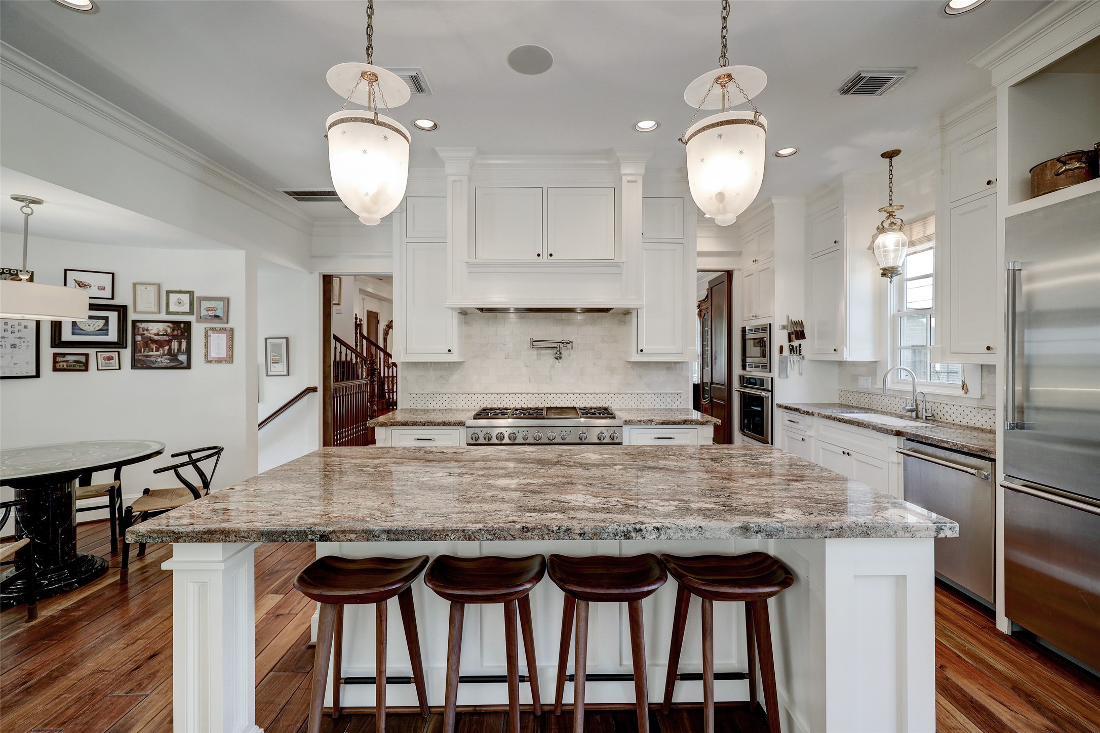 1819 Banks Street Houston, TX 77098 - Photo 16 of 43 a kitchen with kitchen island granite countertop a table chairs stove and refrigerator
