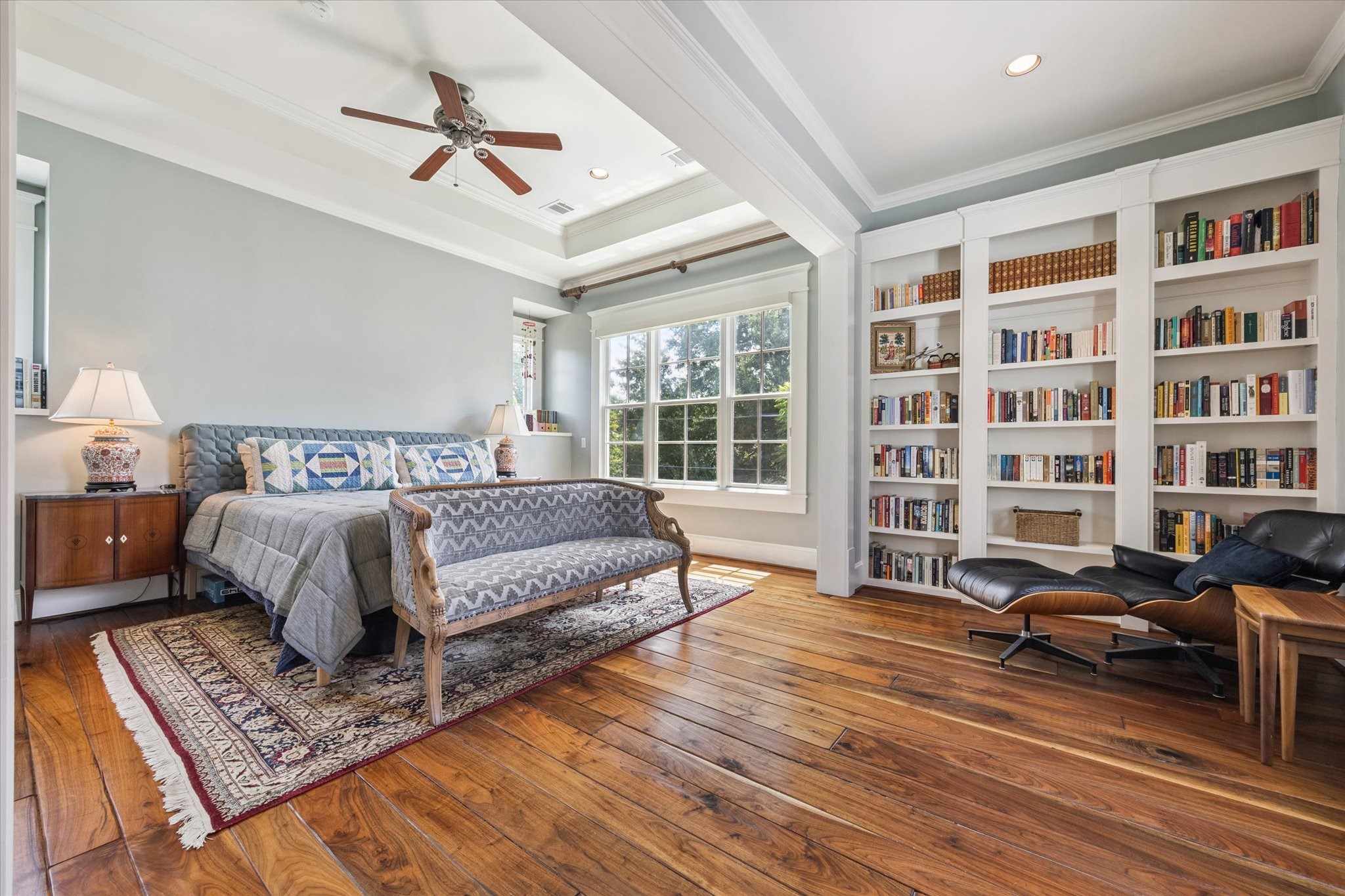 1819 Banks Street Houston, TX 77098 - Photo 23 of 43 a spacious bedroom with a bed a couch and a bookshelf with wooden floor