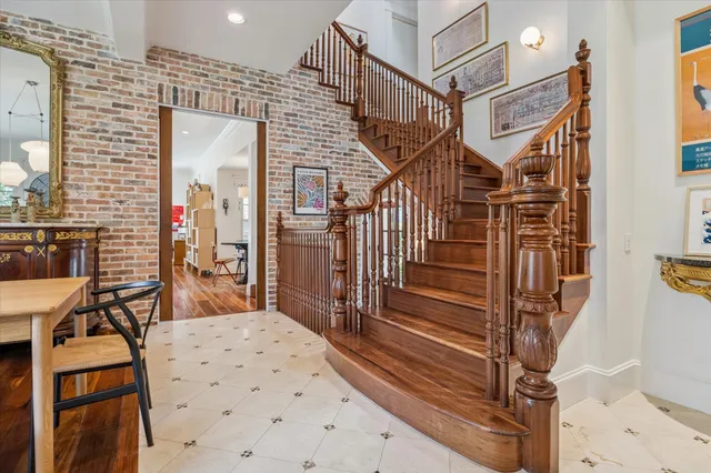 a kitchen with stainless steel appliances granite countertop a stove top oven a refrigerator a sink dishwasher a dining table and chairs with wooden floor