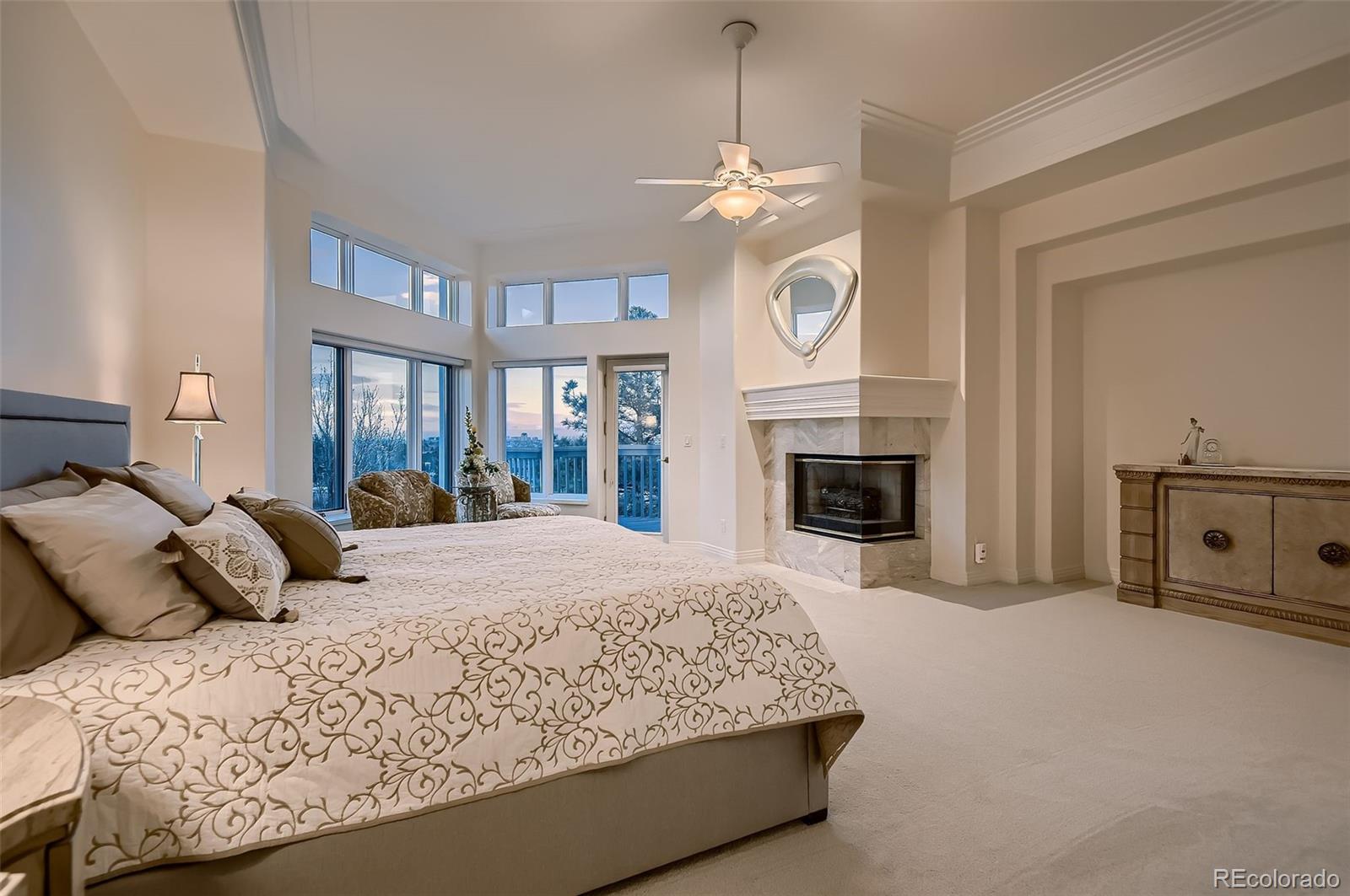 8561 Colonial Drive Lone Tree, CO 80124 - Photo 18 of 50 a bedroom with a large bed and a fireplace