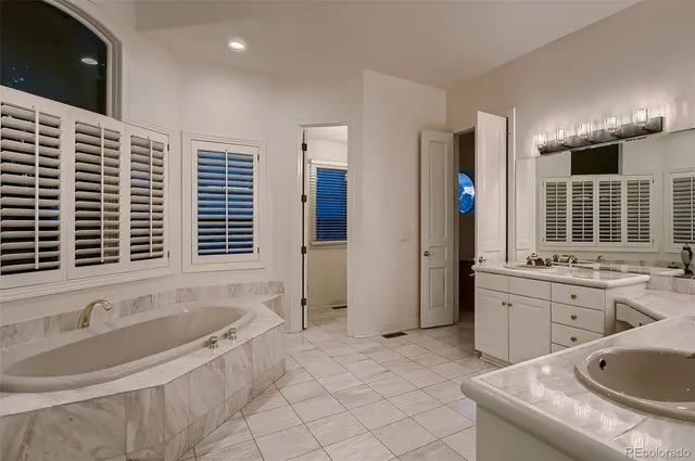 a spacious bathroom with a granite countertop tub sink and mirror