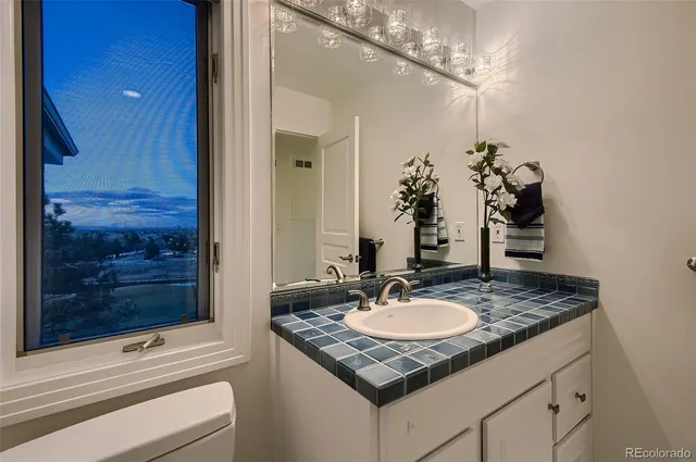 a bathroom with a granite countertop sink a mirror and a shower