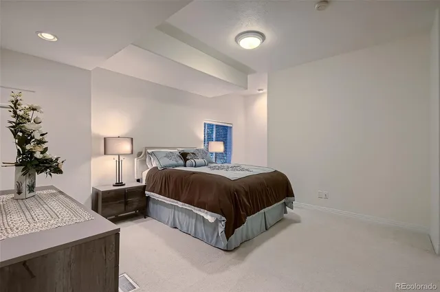 a spacious bedroom with a bed and a lamp
