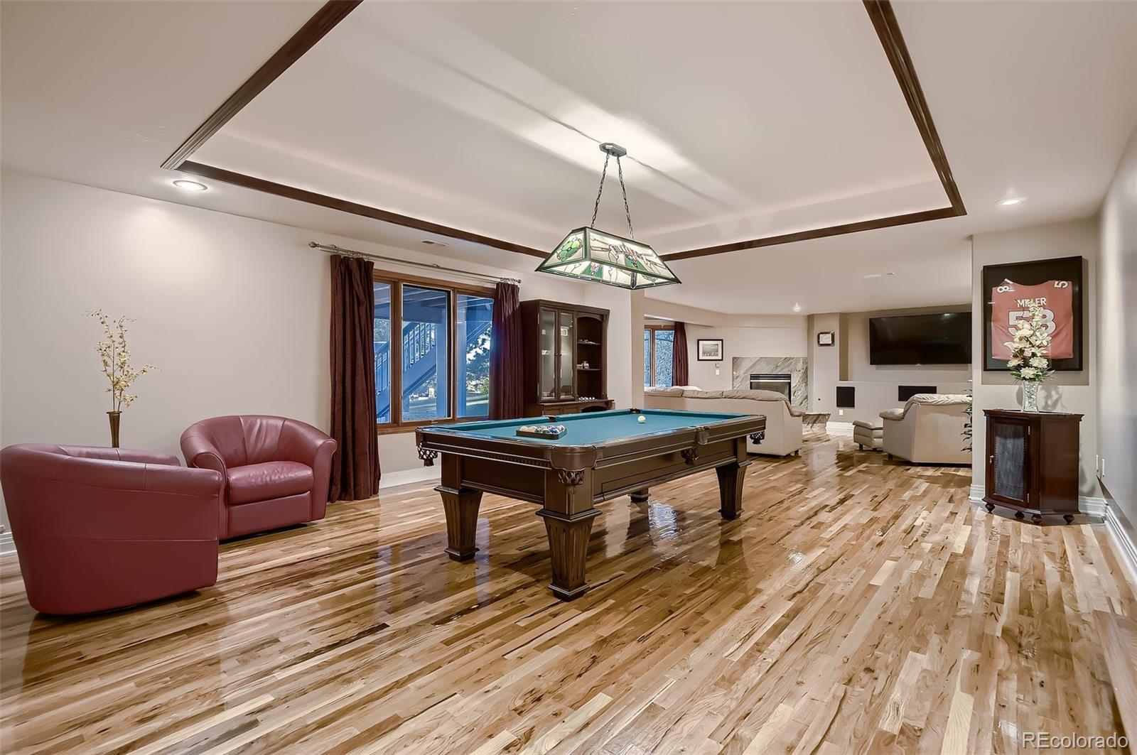 8561 Colonial Drive Lone Tree, CO 80124 - Photo 40 of 50 a living room with furniture a flat screen tv and a floor to ceiling window