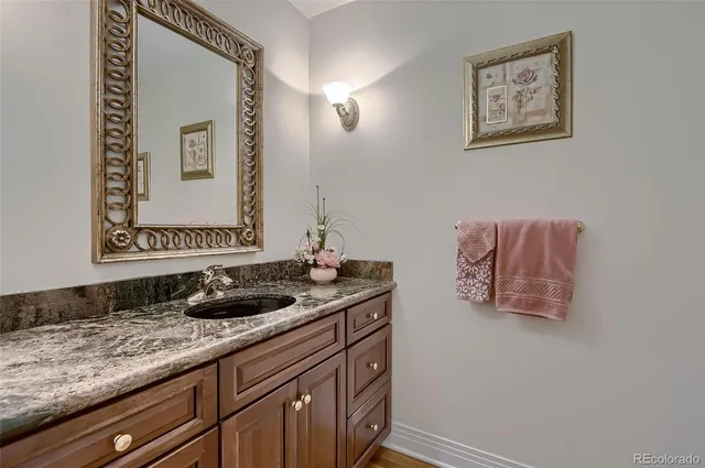a bathroom with a granite countertop sink and a mirror