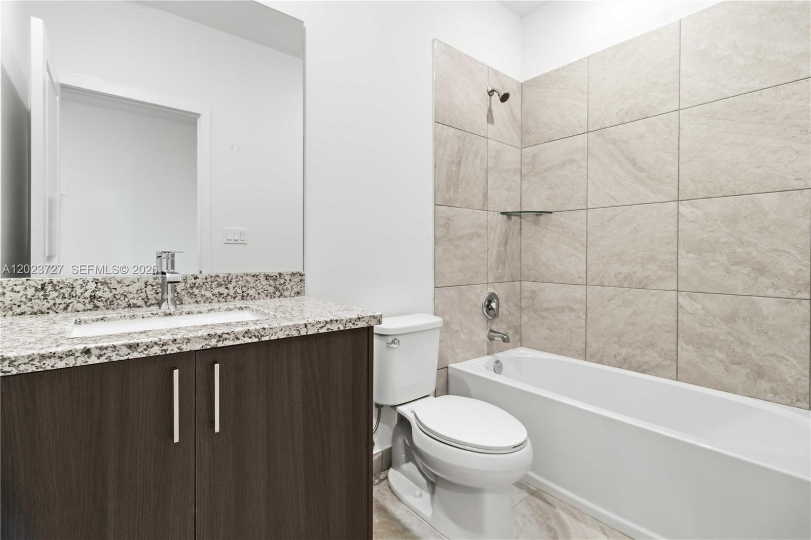 22348 Southwest 115th Court, Unit 22348 Miami, FL 33170 - Photo 16 of 37 a bathroom with a granite countertop sink toilet mirror and bathtub