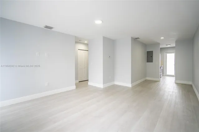 a view of an empty room with wooden floor