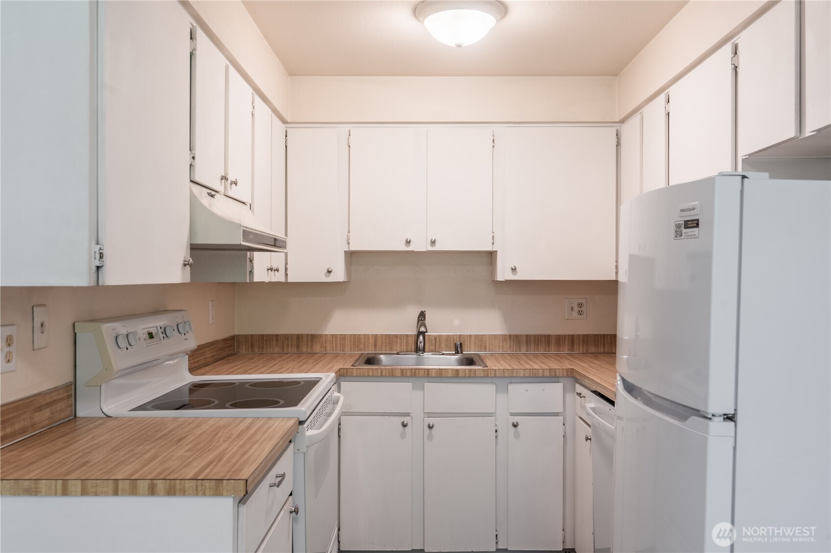 230 Southwest Clark Street, Unit C203 Issaquah, WA 98027 - Photo 5 of 22 a kitchen with granite countertop white cabinets and white appliances