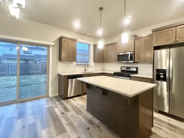 a kitchen with kitchen island a sink stainless steel appliances and cabinets