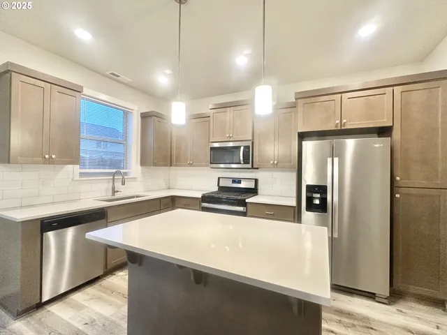 a kitchen with a refrigerator a sink and cabinets