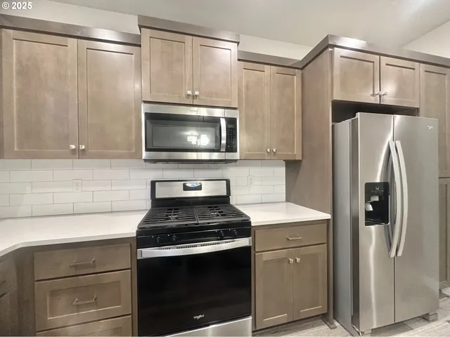 a kitchen with a refrigerator stove and microwave