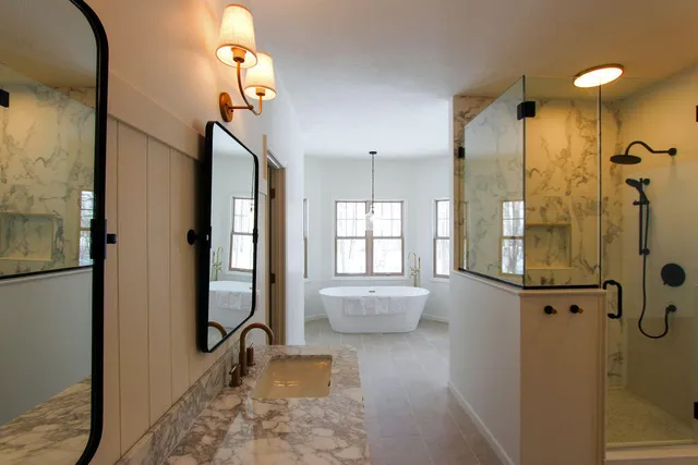 a bathroom with a granite countertop sink mirror and a shower