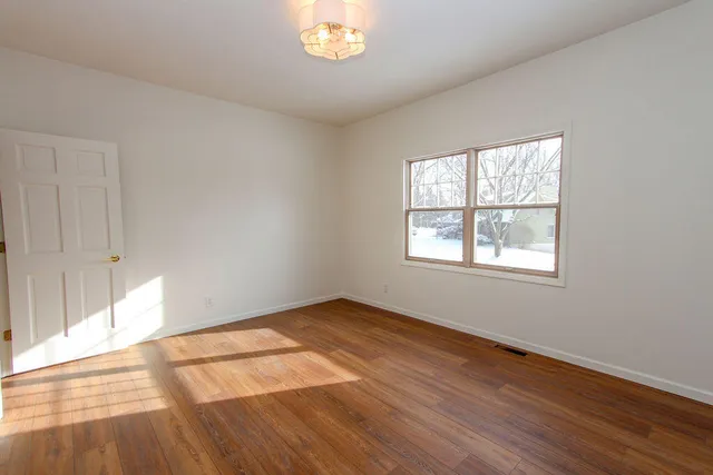 wooden floor in an empty room with a window