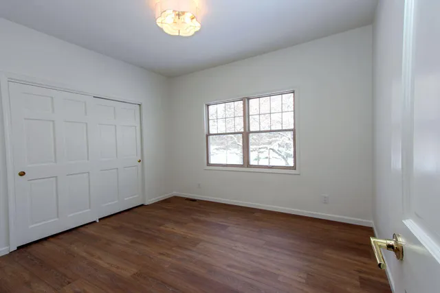 a view of a hallway with wooden floor and staircase