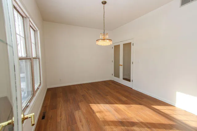 a view of a room with a chandelier fan and a window