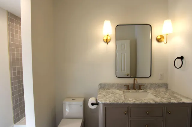 a bathroom with a granite countertop sink and a mirror