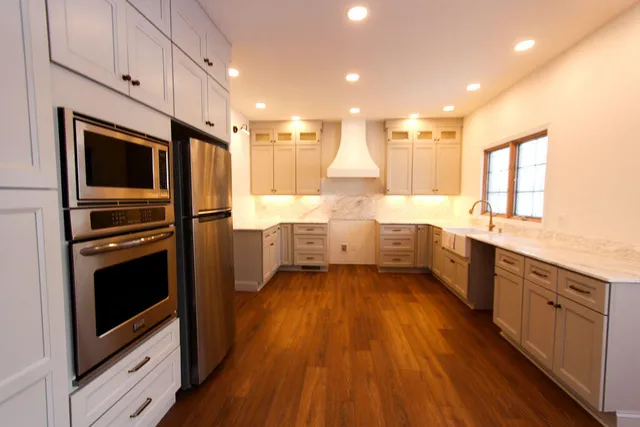 a large kitchen with a large counter top appliances and cabinets
