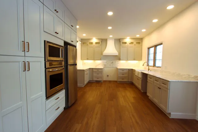 a large kitchen with stainless steel appliances and a refrigerator