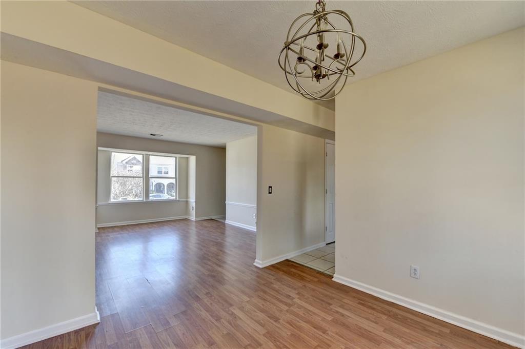 2082 Montgomery Trail Duluth, GA 30096 - Photo 14 of 45 a view of a hallway with wooden floor and a chandelier