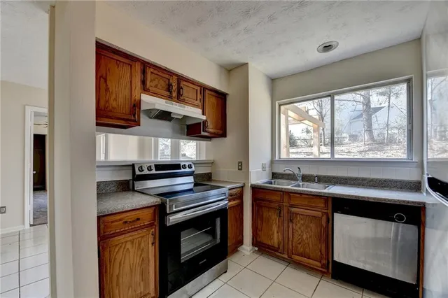 a kitchen with stainless steel appliances granite countertop a stove sink and microwave