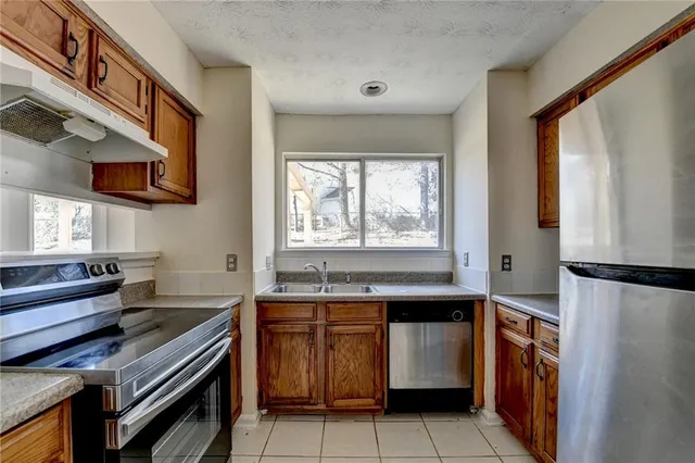 a kitchen with stainless steel appliances a stove a sink and a refrigerator