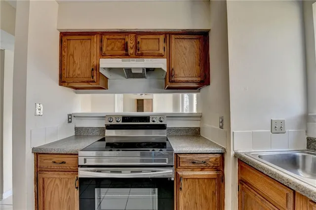 a kitchen with stainless steel appliances granite countertop a stove and a sink