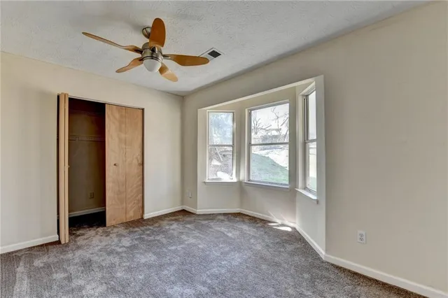 a view of a livingroom with a ceiling fan and window