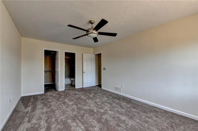 a view of a big room with wooden floor and a ceiling fan
