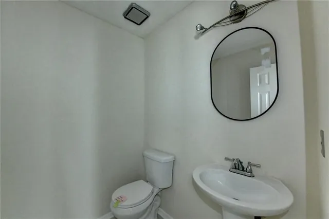 a bathroom with a sink mirror and toilet