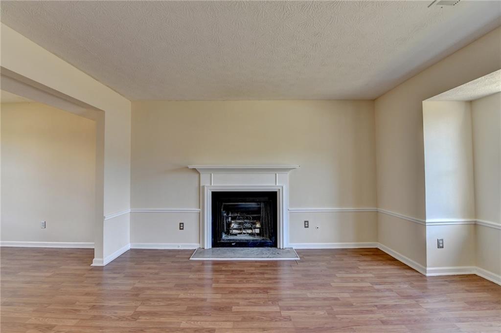 2082 Montgomery Trail Duluth, GA 30096 - Photo 8 of 45 a view of an empty room with wooden floor fireplace and a window