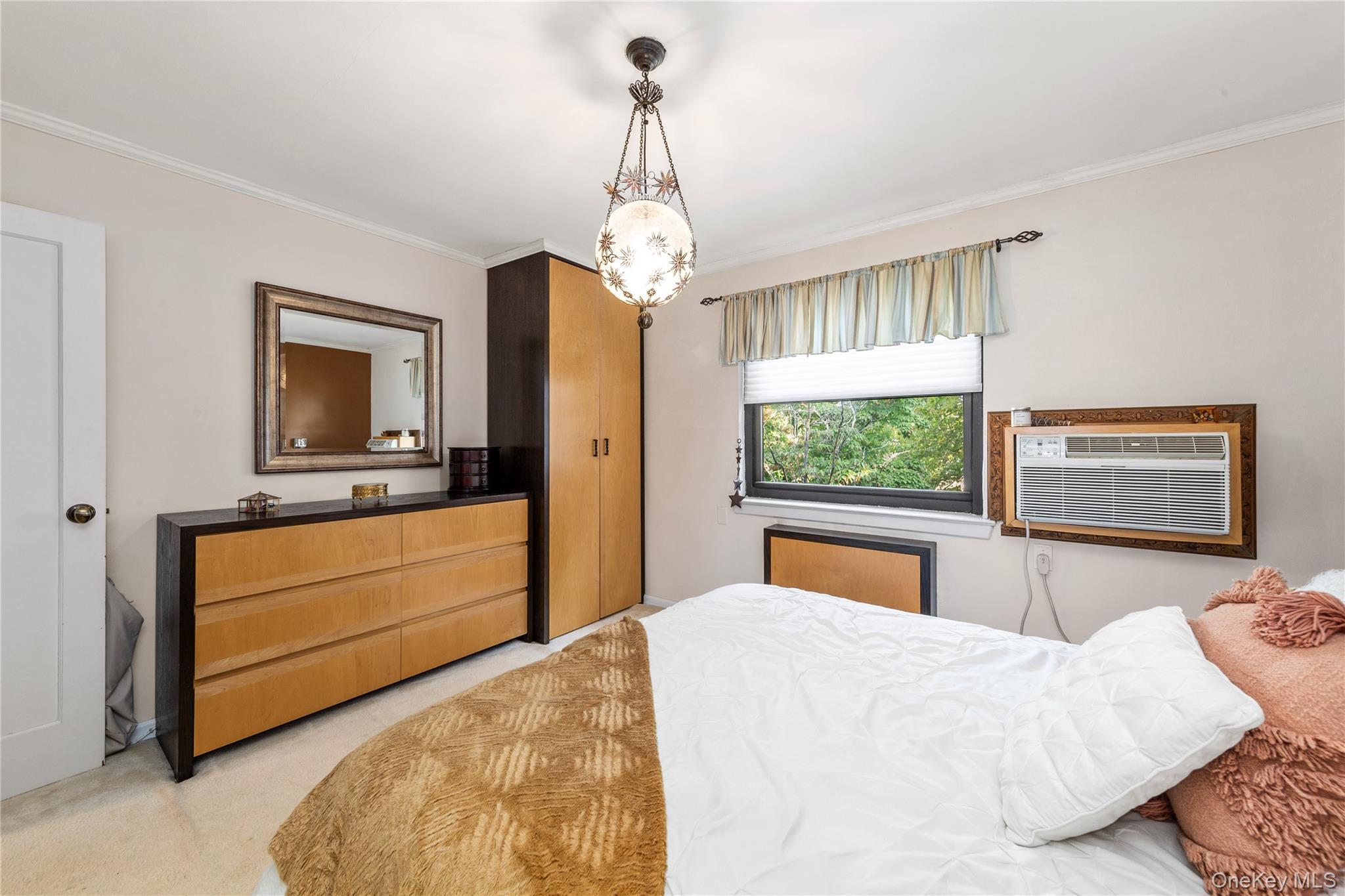 16 Terrace Circle, Unit 14C Great Neck, NY 11021 - Photo 4 of 9 Bedroom with crown molding, light colored carpet, a chandelier, and an AC wall unit