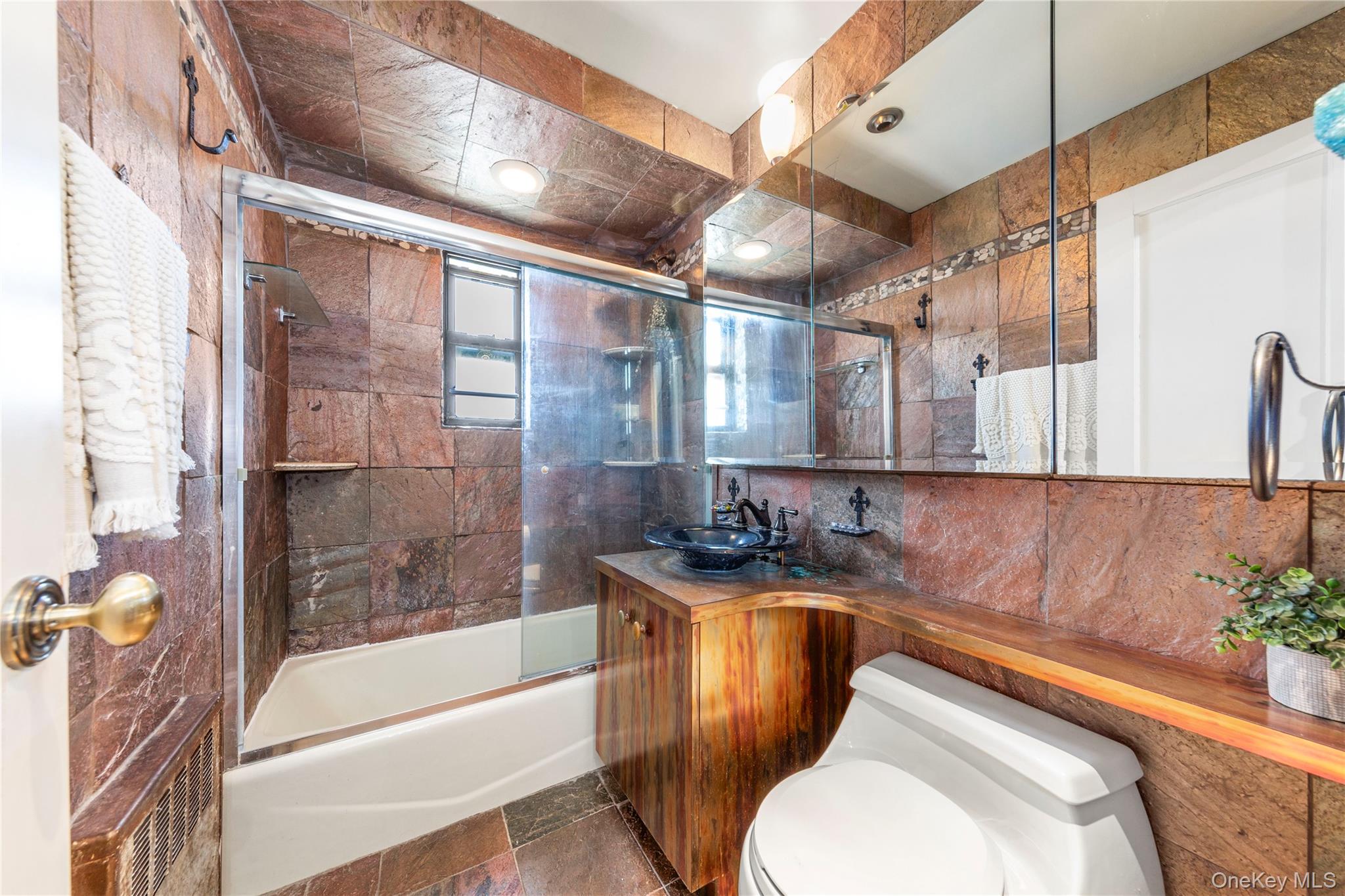 16 Terrace Circle, Unit 14C Great Neck, NY 11021 - Photo 7 of 9 Full bath with bath / shower combo with glass door, tile walls, vanity, and decorative backsplash