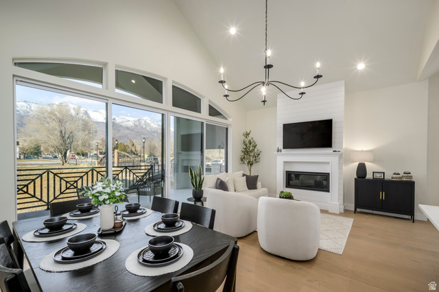 250 South Main Street, Unit 25 Alpine, UT 84004 - Photo 12 of 31 Dining area with light wood-style flooring, suspended lighting, vaulted ceiling, and a large fireplace