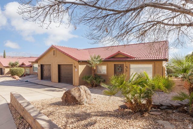 161 West 950 South, Unit S4 St. George, UT 84770 - Photo 2 of 21 View of front of home featuring stucco siding, a tiled roof, driveway, and an attached garage