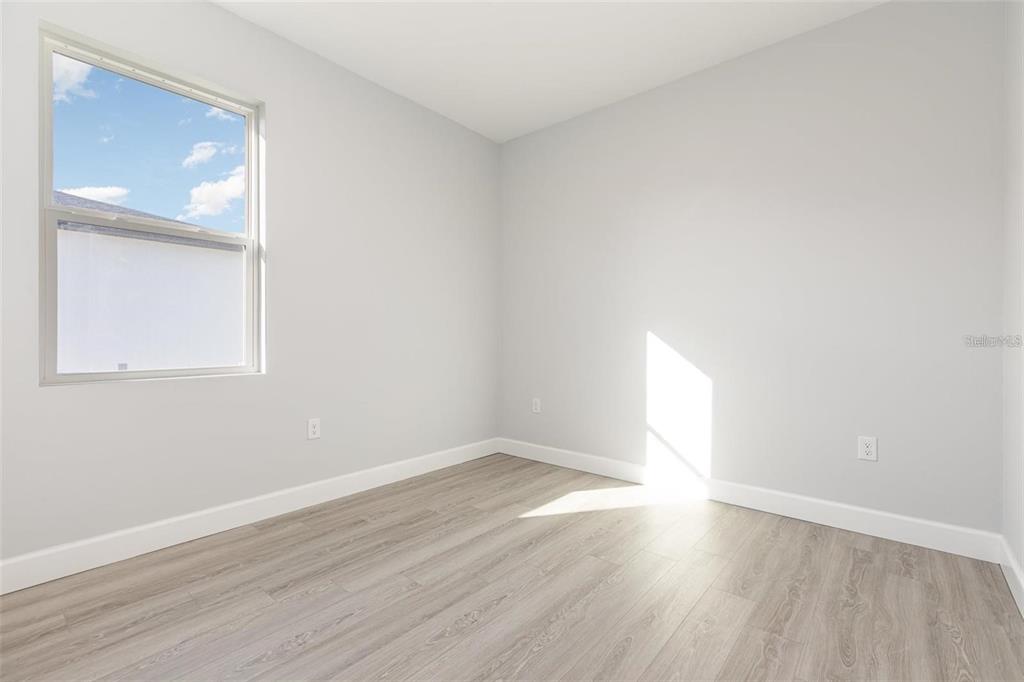 13451 Kaplan Terrace Port Charlotte, FL 33981 - Photo 14 of 27 an empty room with wooden floor and windows